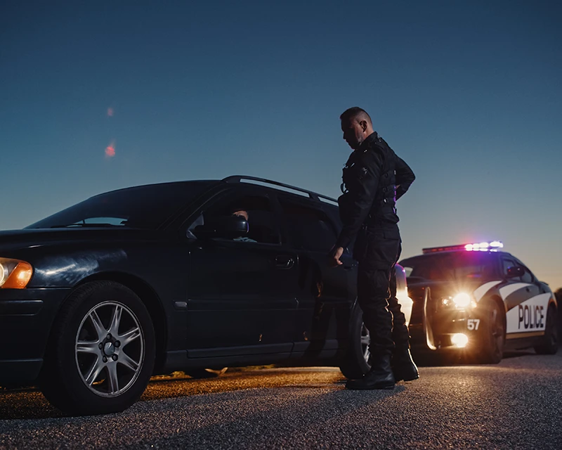 A police officer stands next to a car he has just pulled over