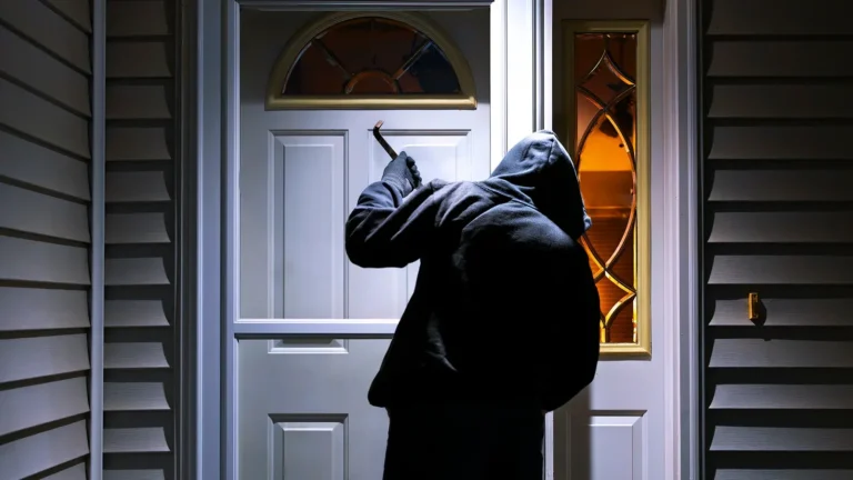 a man in hoodie breaking in a house